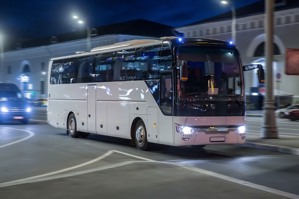 Tourist bus moves at night on a city street